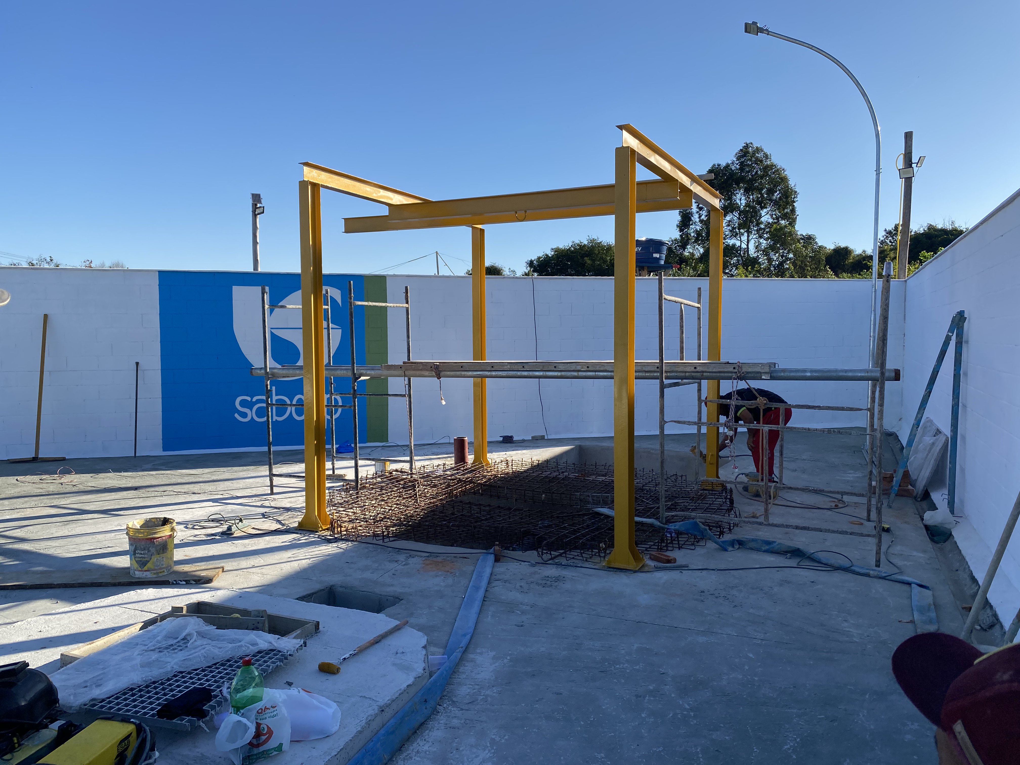 Estrutura metálica amarela para cobertura técnica em obra da Sabesp